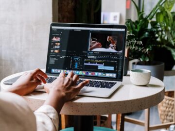 person using macbook pro on white table