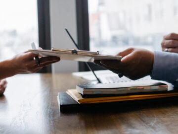 crop black job candidate passing resume to hr employee