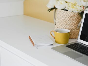 yellow mug besides laptop